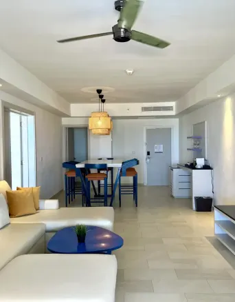 Living room with sofa, table, chairs, TV, and ceiling fan