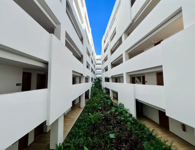 white building with multiple floors and a central garden