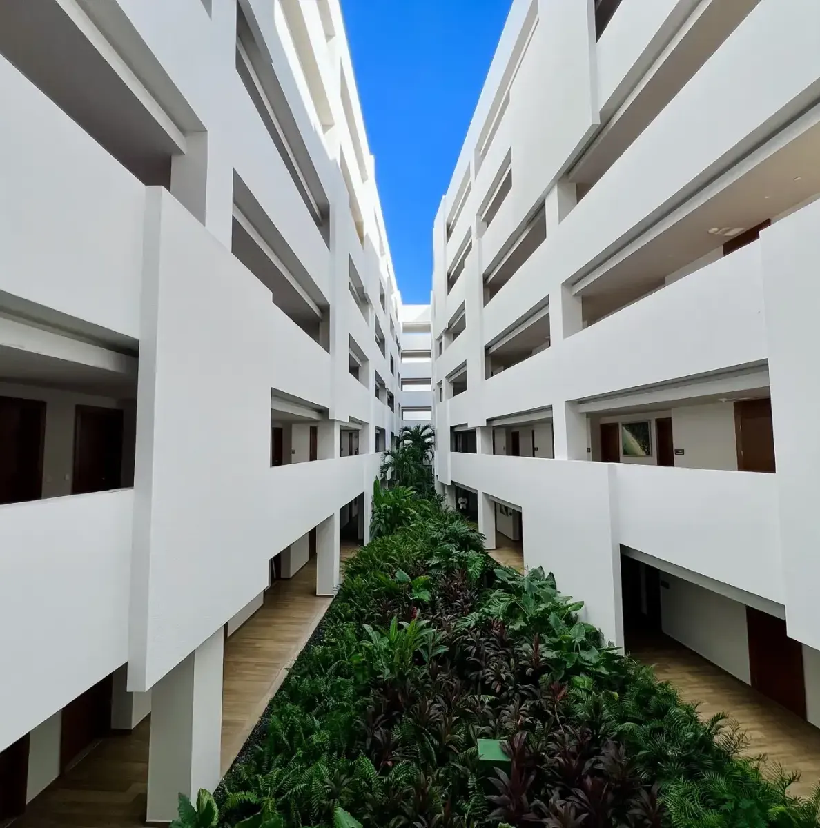 white building with multiple floors and a central garden