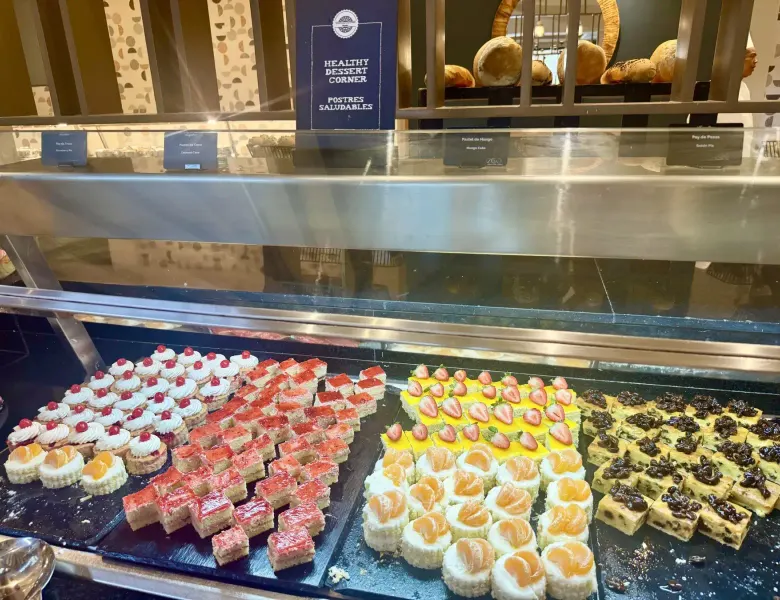 Dessert display with various cakes and pastries in a glass case