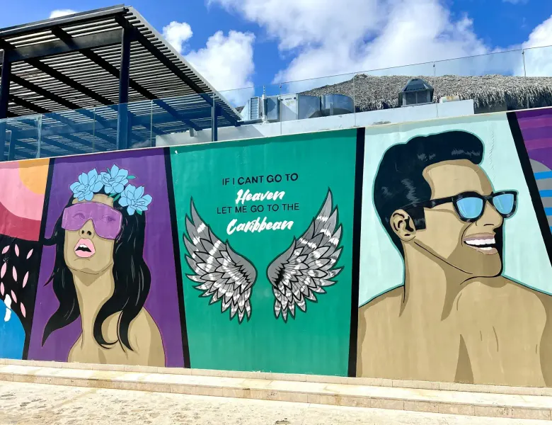 mural with woman, wings, man, and text on a wall