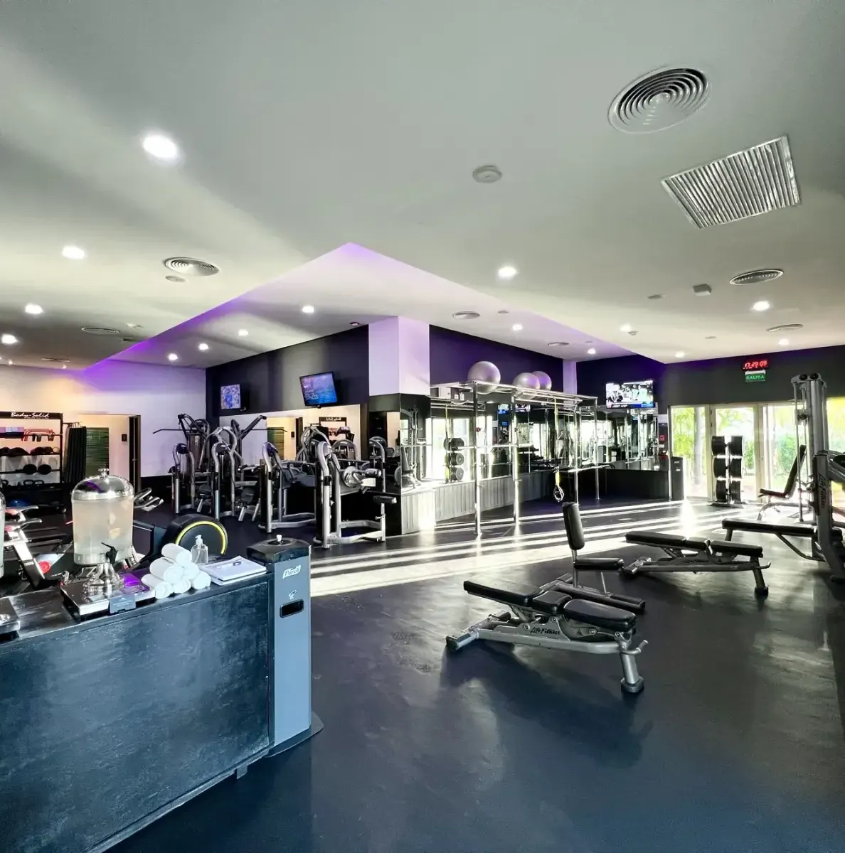 gym with exercise equipment, water dispensers, and people in background