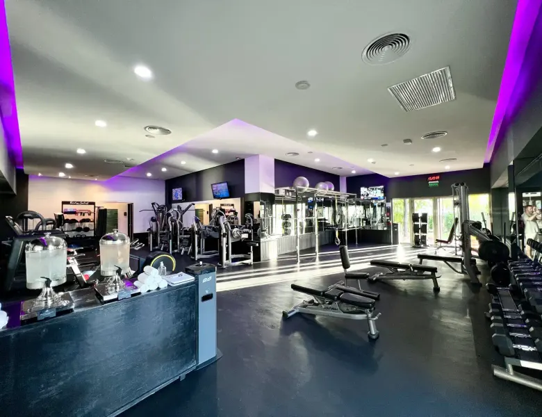 gym with exercise equipment, water dispensers, and people in background