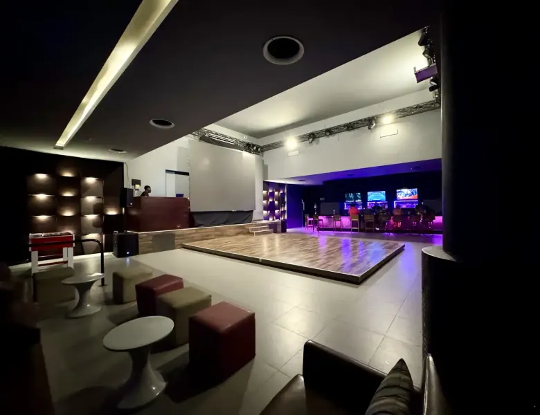 stage, seating, tables, bar area, screens, lighting