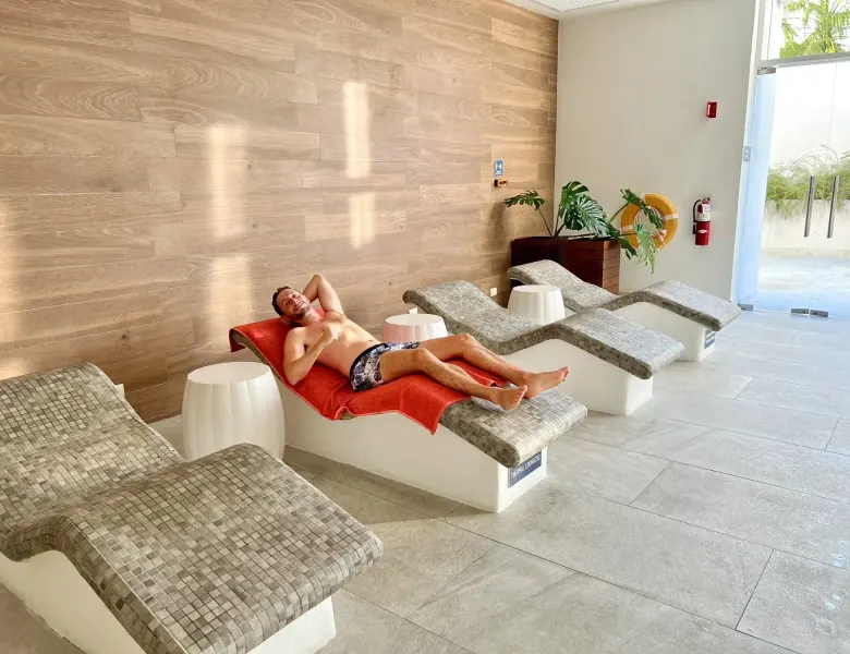 Man lying on lounge chair with red towel in spa area