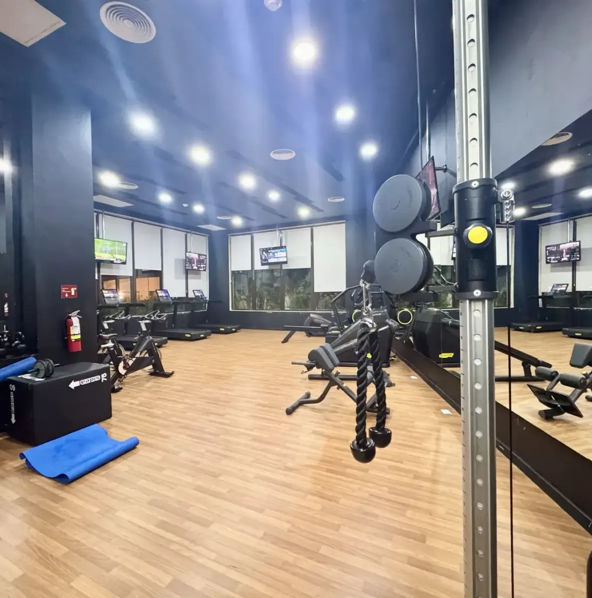 gym with exercise equipment, mirrors, and wooden flooring