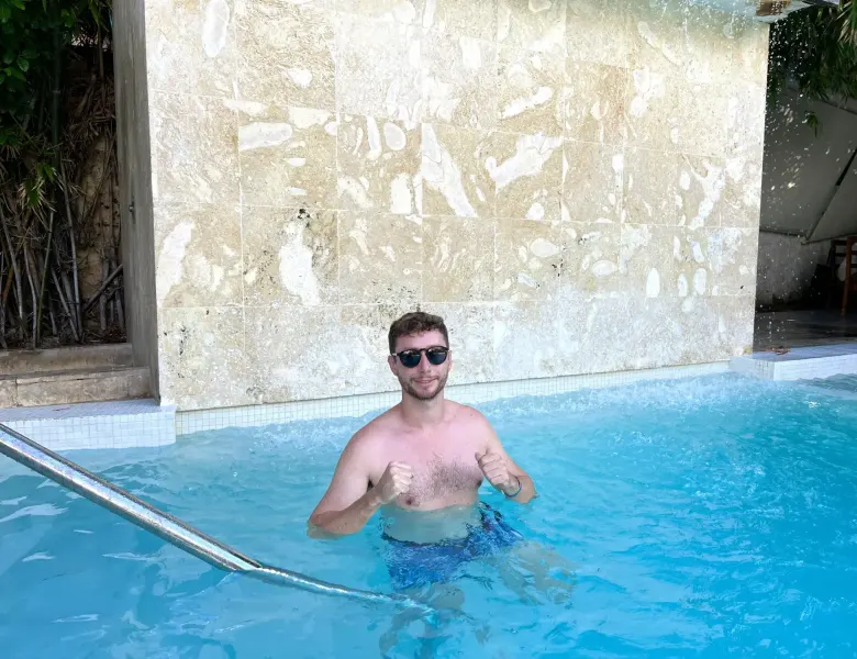 Man in pool with tiled wall and metal handrail