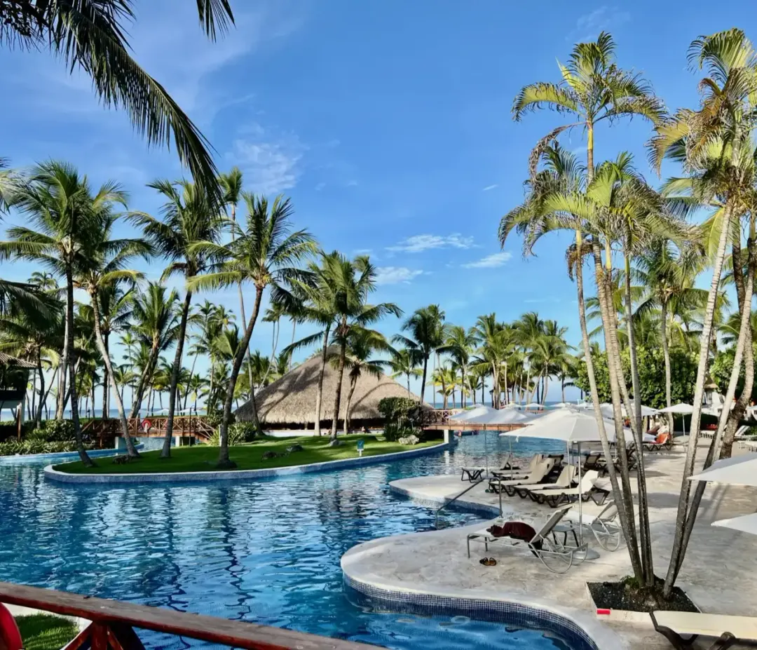 The main pool at Wyndham Alltra Punta Cana, palms along the far edge.